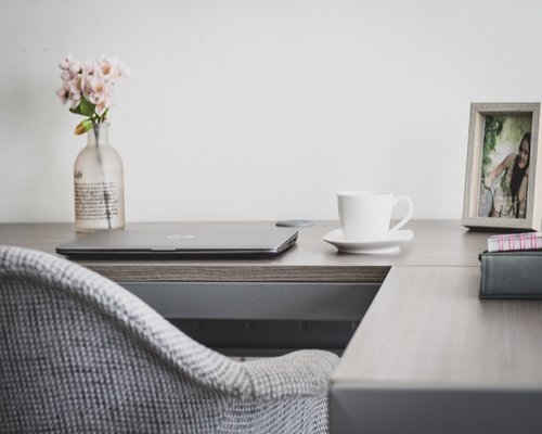 Person stretching arms while sitting at a home office desk